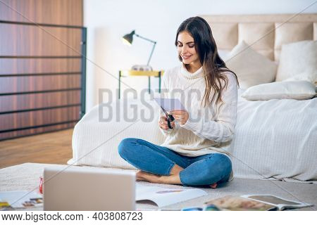 Dark-haired Young Woman Cutting Pistures From Magazines And Making A Wishlist