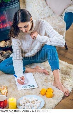 Woman Sitting On The Floor And Prepapring Her Wishlist