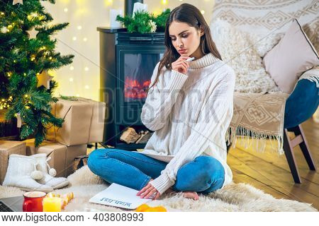 Woman Prepapring Her Wishlist And Looking Thoughtful