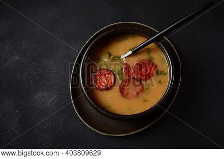 Caldo Verde Soup With Greens And Chopped Chorizo On The Top In The Bowl On A Dark Background.