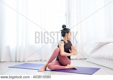 Young Woman Do Yoga In A Bed Room