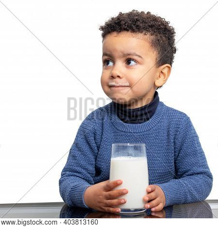 Close Up Portrait Of Cute Afro American Boy Holding Glass Of Milk At Table. Kid With Milk Mustache I