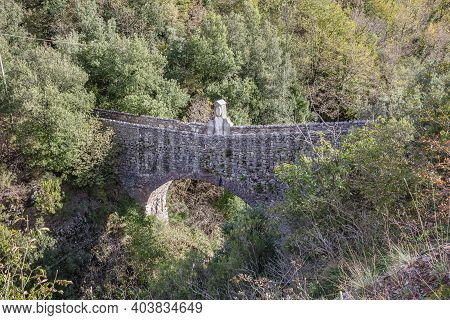 Old Stone Bridge Leading To Small Mountain Village With A Few Remaining Residents