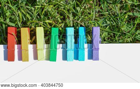 A Mood-boosting Color Concept, Multi-colored Wooden Clothespins In A Row Against A Background Of Gre