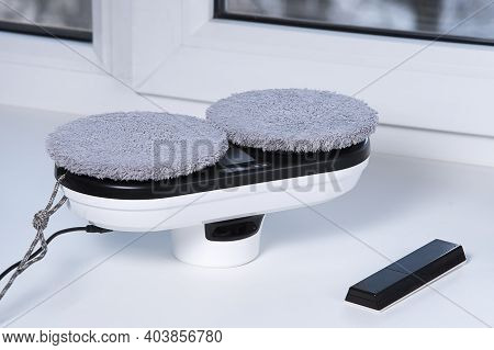 Downside Of Vacuum Cleaner Robot For Washing Glass Window On White Windowsill. Robot Assistant At Ho