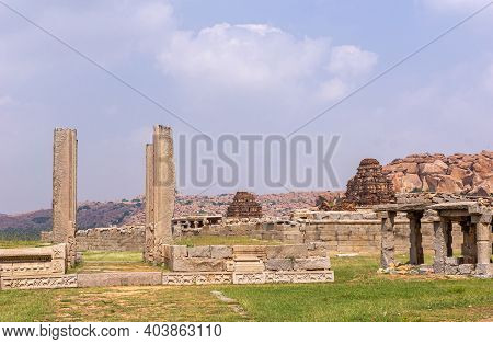Hampi, Karnataka, India - November 5, 2013: Vijaya Vitthala Temple Red Stone Gopurams Behind Beige S
