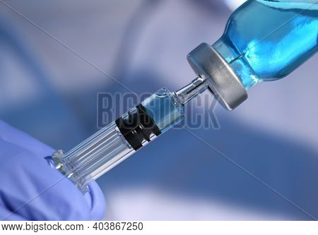 Woman Filling Syringe With Vaccine From Vial, Closeup