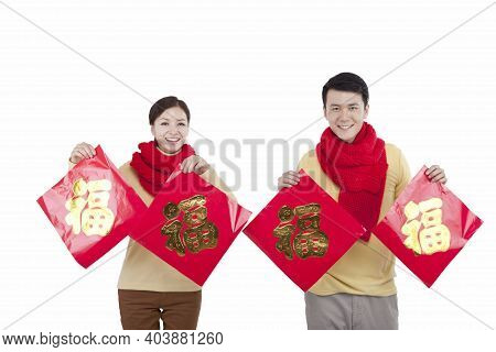 Portrait Of Young Couple Holding A Chinese Good Luck Fus, Paying New Year Call