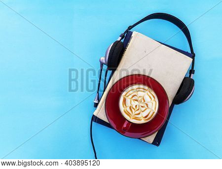 Audio Book Concept. Black Headphones With Books And Cup Of Fresh Coffee On Blue Background. Top View