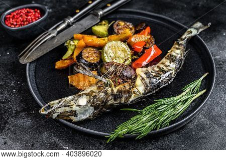 Baked Whole Icefish With Grilled Vegetables. Black Background. Top View