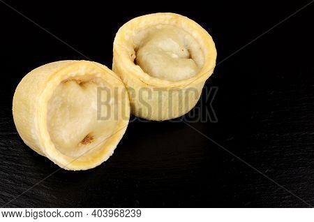 Two Individual Steamed Steak And Kidney Puddings In Suet Pastry Cases On A Slate Background