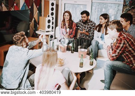 Group Of Friends Gathering Around Table At Home.