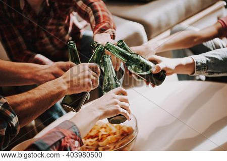 Group Of Friends Gathering Around Coffee Table At Home. Friends Gathered At The Table And Drinking B