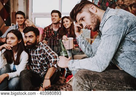 Group Of Friends Gathering Around Coffee Table At Home. Friends Gathered At The Table And Drinking B