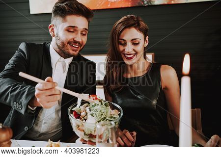 Group Of Friends Gathering Around Coffee Table At Home. Friends Gathered At The Table And Drinking B