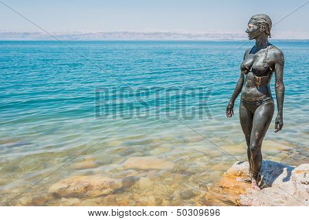one caucasian woman applying dead sea mud body care treatment  in jordan