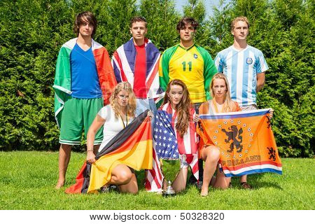 International sports team with men and women from various nationalities, each dressed in the color of their nation, holding their county's flags