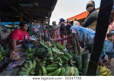 PADANG - AUGUST 25: A vendor sells banana and farm produce at her stall at a village market in Padang, Sumatera, Indonesia on August 25, 2013. Agriculture and fishery is an important industry here.