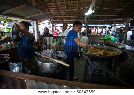 PADANG - AUGUST 25: Food hawkers prepare rice dishes at their stall at a village market in Padang, Sumatera, Indonesia on August 25, 2013. Farming, food products and fishery is a major industry here.