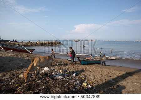 PADANG - AUGUST 25: A fisherman takes his boat to shore in a busy fishing village in Padang, West Sumatera, Indonesia on August 25, 2013. Resources from the sea is a major revenue earner.  