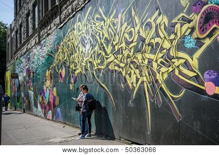 Tourist couple check city map in front of a mural in Pioneer Square