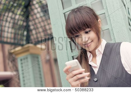 Attractive business woman use cellphone, portrait in outside, Taipei, Taiwan, Asia.