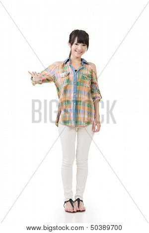 Asian woman puts hand on something imaginery. Full length portrait. Isolated on the white background.