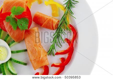 smoked salmon slices with vegetabls over white plate