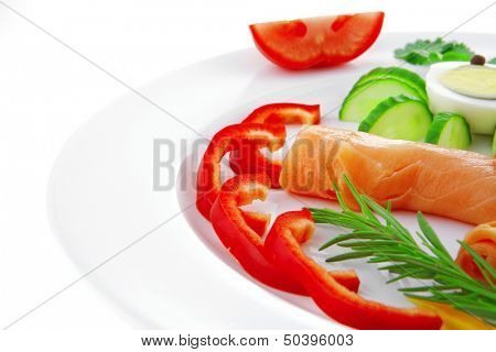 smoked salmon slices with vegetabls over white plate