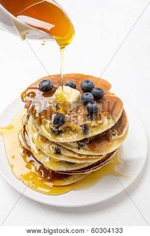 Big Pile of American Blueberry Pancakes with Berries and Maple Syrup