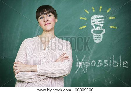 Woman Smiles Writes On A Blackboard The Concept Of Saving Energy Is Possible