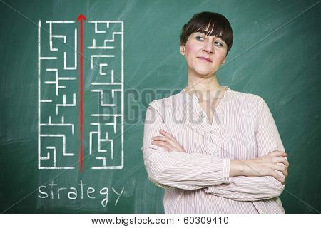 Woman Smiles Writes On A Blackboard The Concept Of Strategy