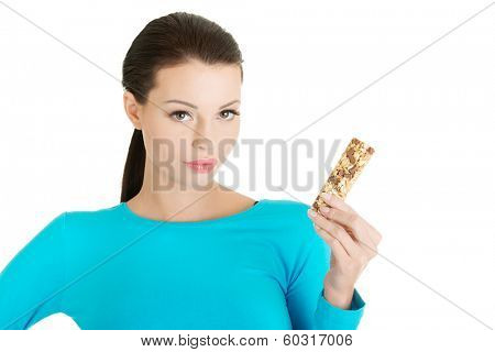 Young woman eating Cereal candy bar, isolated on white 