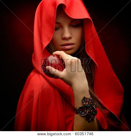 beautiful woman with red cloak hoding red apple