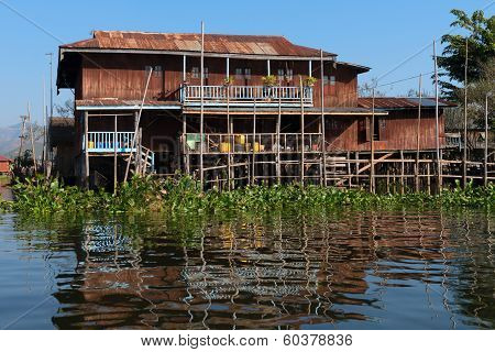 Traditional Stilts House In Water Under Blue Sky