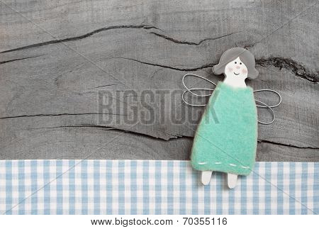 Blue Christmas Or Guardian Angel With Checkered Fabric On Grey Wooden Background