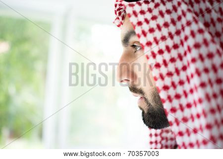 Arabic young sheikh looking trough the window