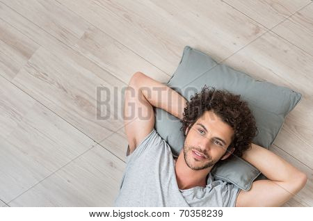 High Angle View Of Young Man Lying On Floor Thinking