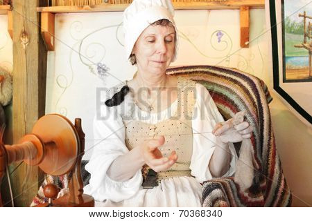 MUSKOGEE, OK - MAY 24:  A woman works at a vintage spinning wheel making yarn at the Oklahoma 19th annual Renaissance Festival on May 24, 2014 at the Castle of Muskogee in Muskogee, OK 