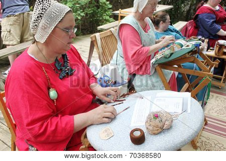 MUSKOGEE, OK - MAY 24: Women show art of lace making, as it was made in the Middle Ages, at the Oklahoma 19th annual Renaissance Festival on May 24, 2014 at the Castle of Muskogee in Muskogee, OK 