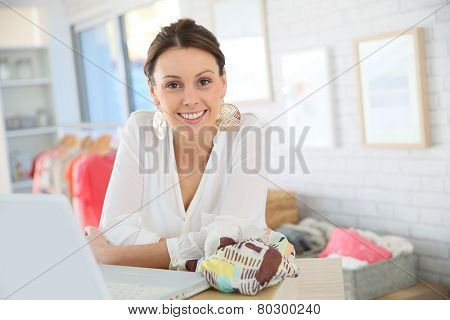 Beautiful shopgirl working in clothing store