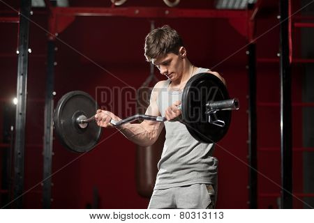 Young Man Lifts Weight In Gym