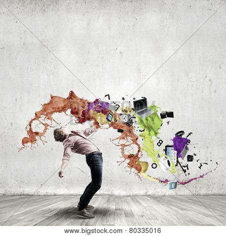 Young guy in casual evading from colorful splashes