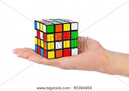 MOSCOW, RUSSIA - August 31, 2014: Hands and Rubik's cube puzzle isolated on the white background. Cube was invented by a Hungarian architect Erno Rubik in 1974.