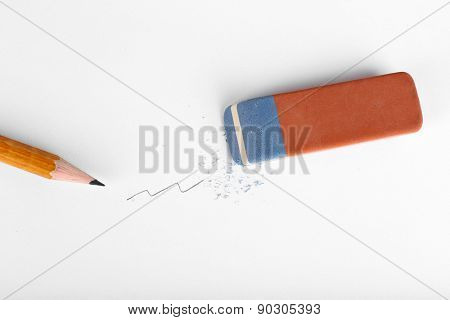 Eraser and pencil on paper background