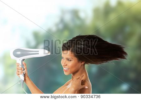 Young happy woman drying her hair.