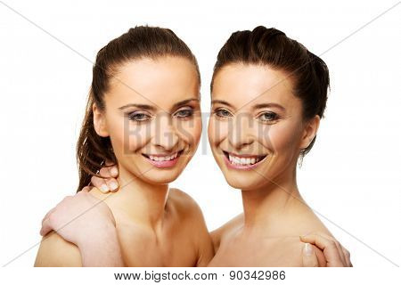 Two attractive sisters with make up embracing.