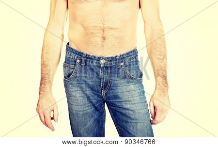 Close up on shirtless men in jeans trousers. 