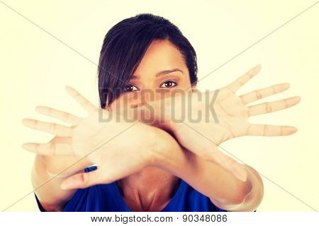 Young mulato woman making stop sign.