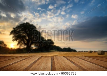 Rural Landscape Image Of Summer Sunset Over Field Of Hay Bales With Wooden Planks Floor